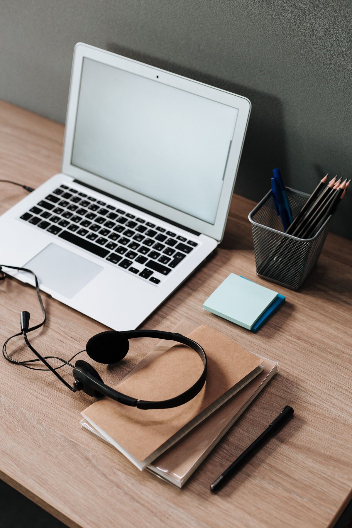 Research desk with laptop, notebook, stationery, and headset