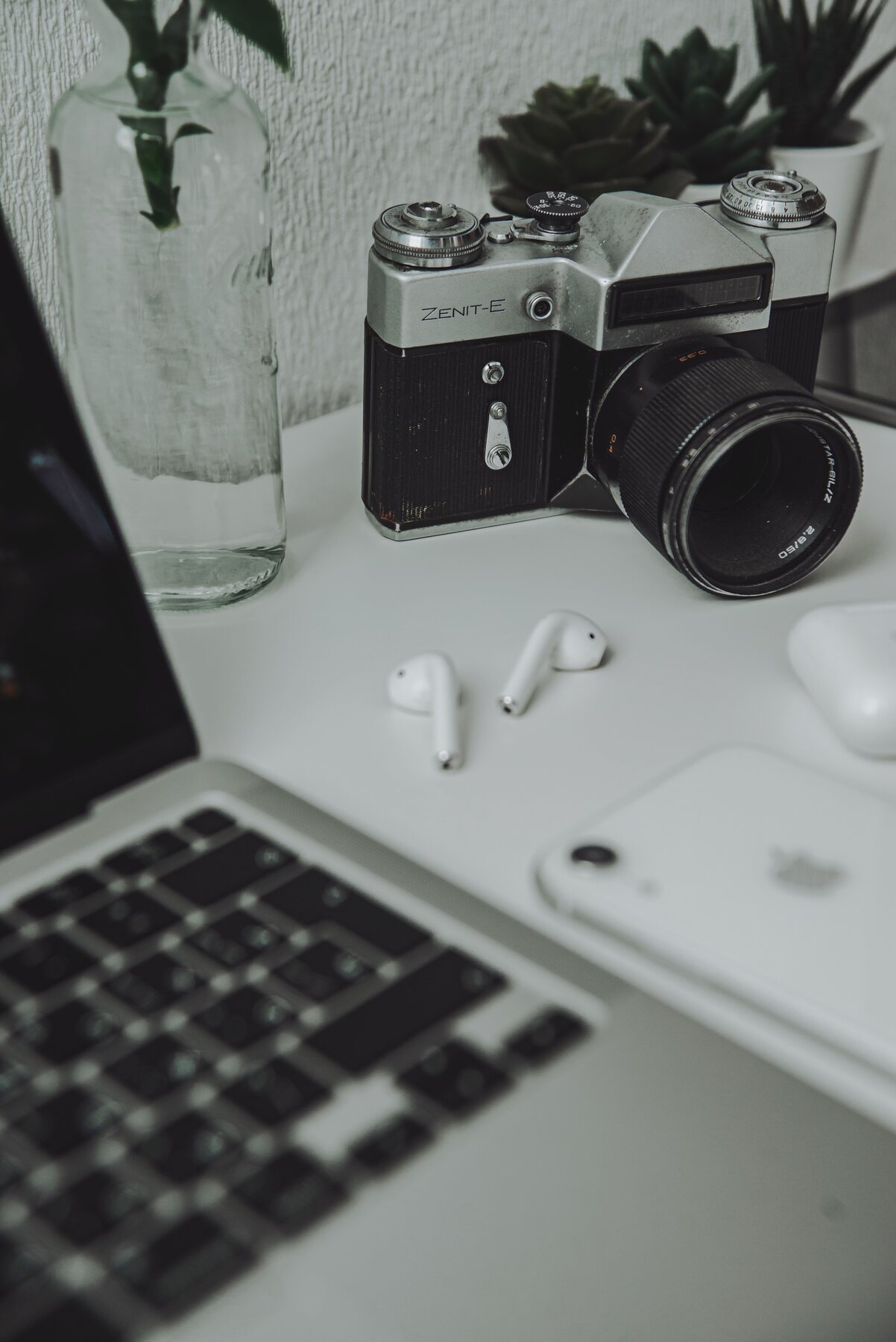 A curated selection of everyday technology and camera accessories arranged on a desk
