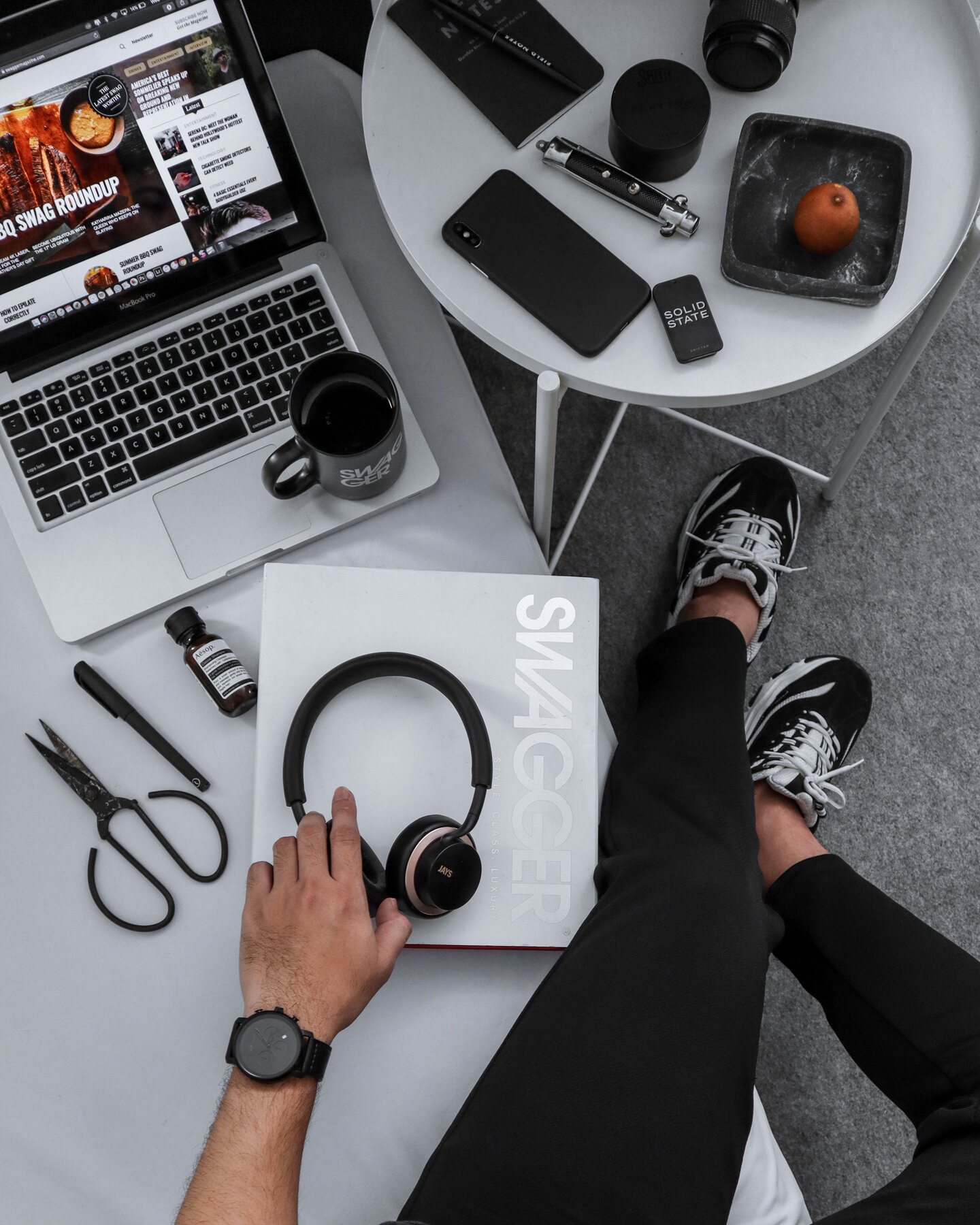 Person comparing headphones and everyday technology at a desk